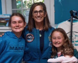 Retired NASA astronaut Nicole Stott poses for a picture with two young attendees.