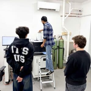 Emon explains the lab instrument to GSA students during their class.
