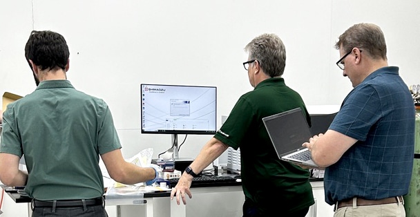 Three men review the instrument in Shaw Institute's lab building.